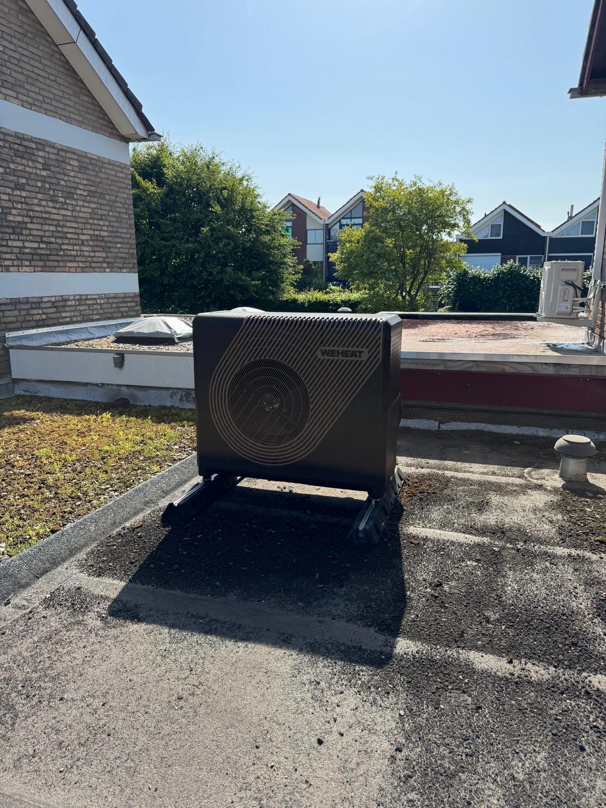 Weheat warmtepomp buitenunit op een plat dak