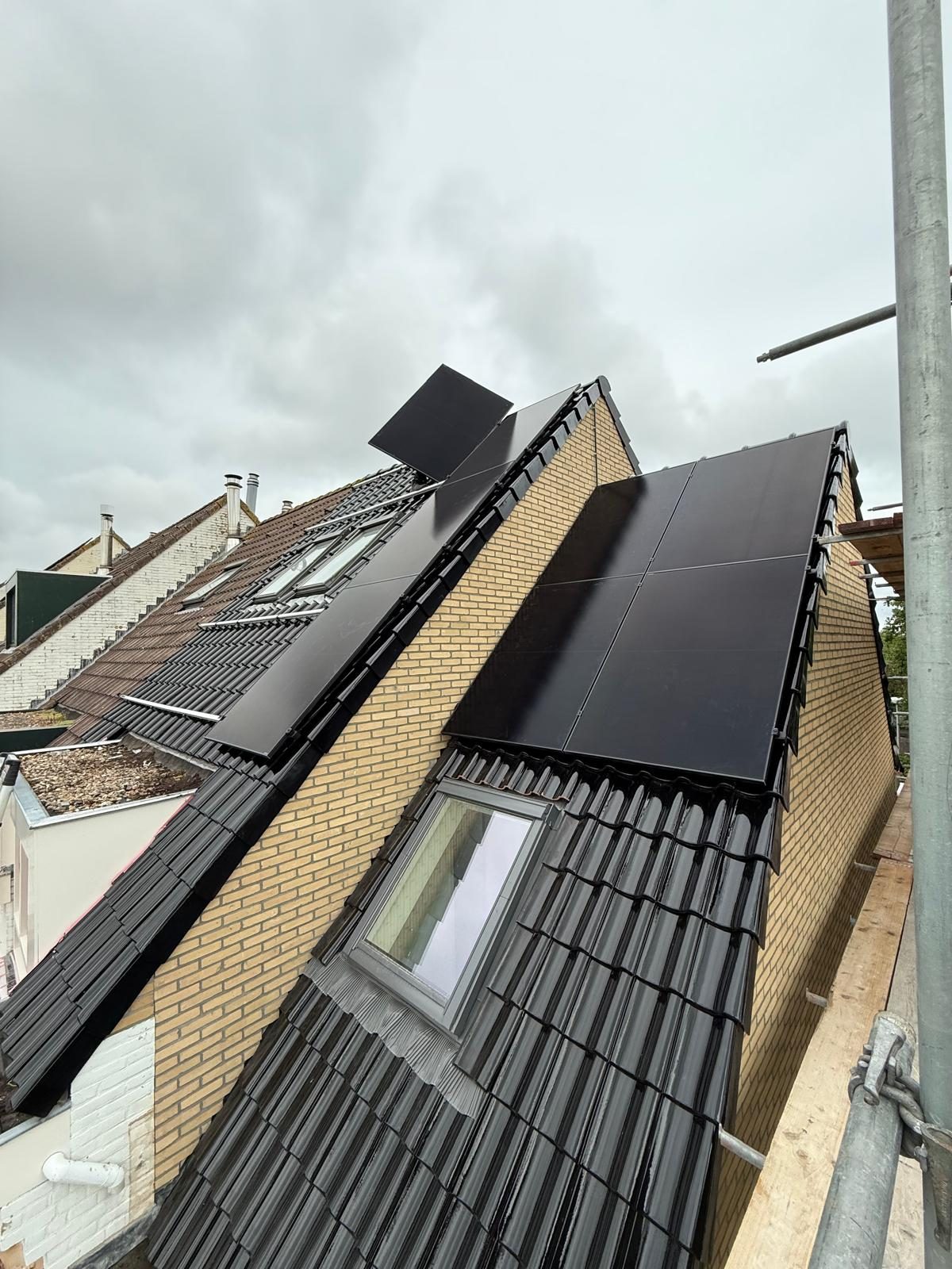 Installatie van zonnepanelen op een hellend dak vanaf de steiger